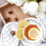 Hazelnut Vanilla tea from Smooth Teas in a cup next to hazelnuts and flowers